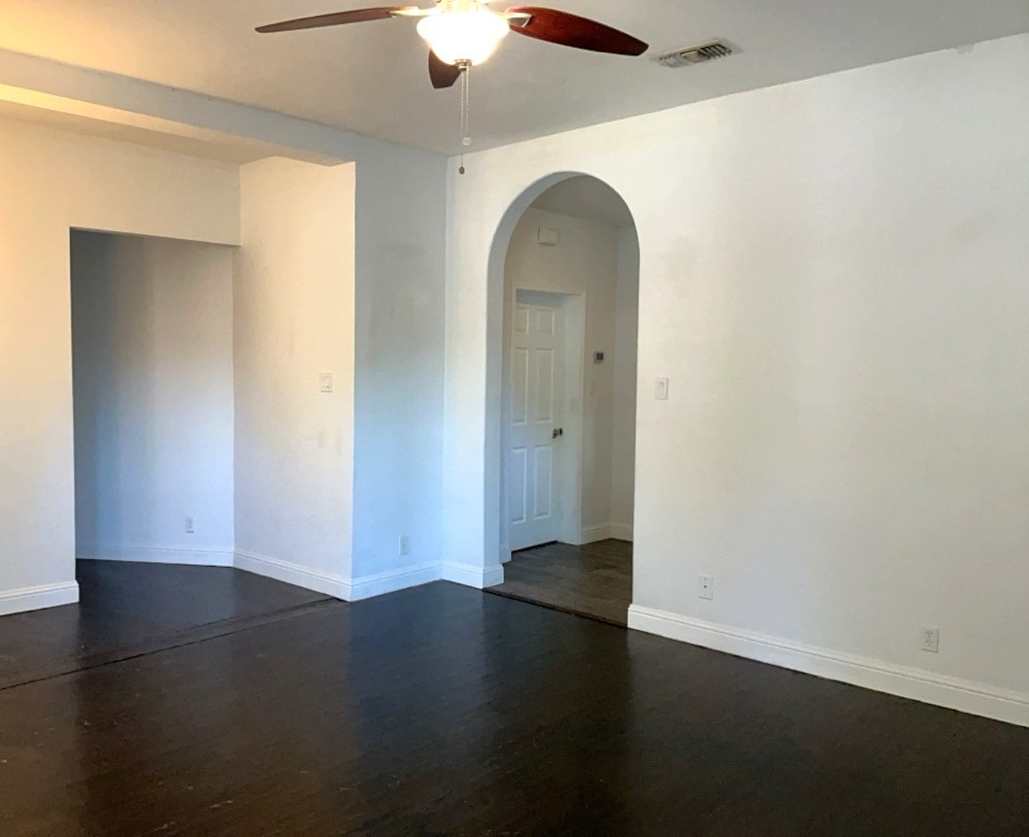 806 East 3rd Street Georgetown, TX 78626 - Photo 2 of 16 Unfurnished room with dark wood-type flooring, arched walkways, and ceiling fan