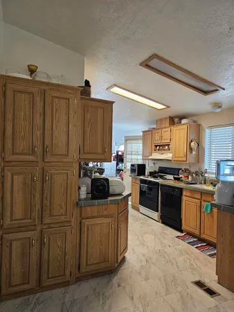 a kitchen with stainless steel appliances granite countertop a refrigerator and a stove top oven