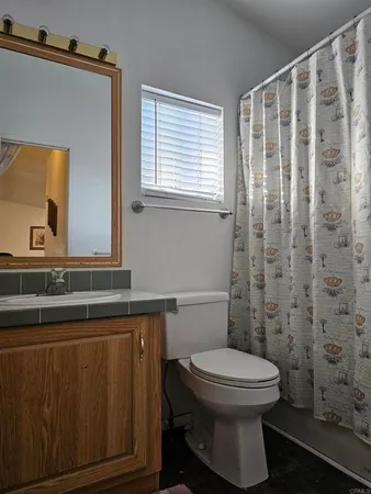 a bathroom with a toilet a sink and a mirror