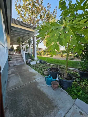 a view of a patio with table and chairs potted plants with wooden fence
