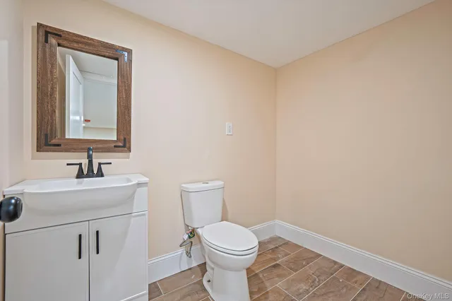 a bathroom with a toilet a sink a vanity and mirror