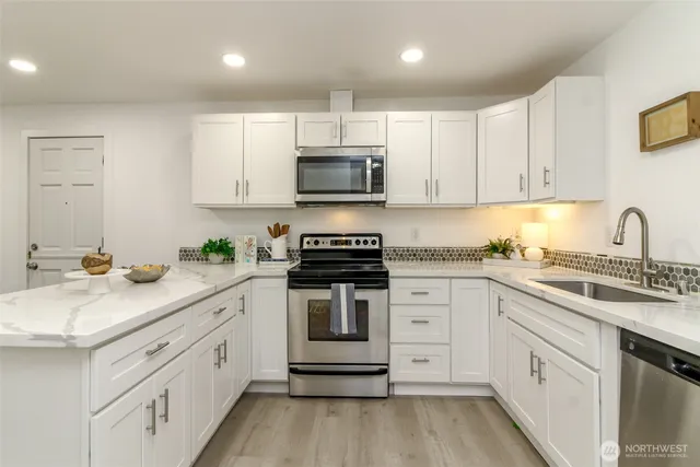 a kitchen with granite countertop white cabinets and white appliances