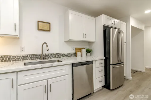 a kitchen with appliances a refrigerator and cabinets