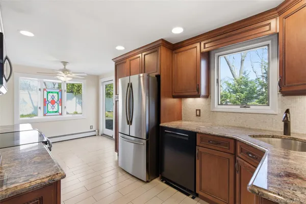 a kitchen with stainless steel appliances granite countertop a refrigerator and a sink