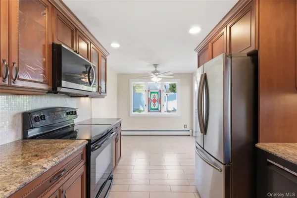 a kitchen with stainless steel appliances granite countertop a refrigerator a stove a sink and dishwasher