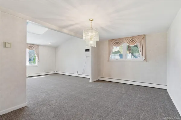 an empty room with windows and chandelier