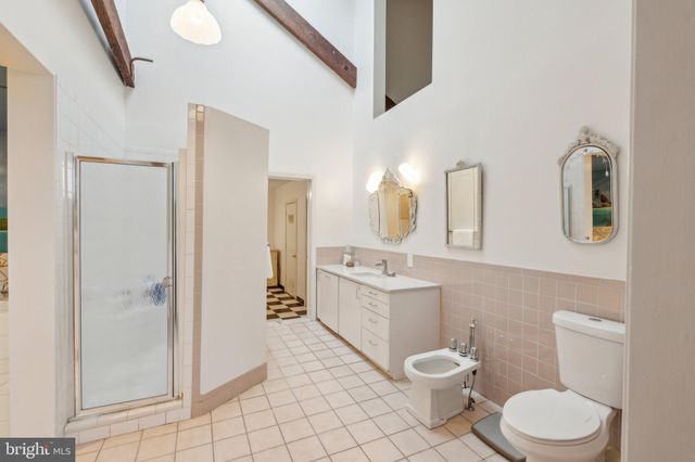 a bathroom with a tub and a view of bedroom
