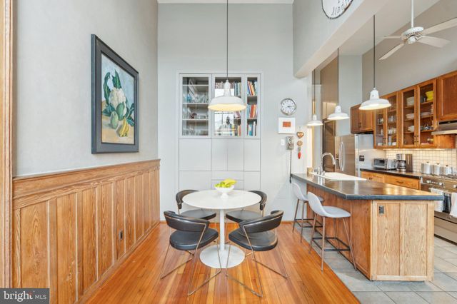 a kitchen with cabinets a sink and chairs