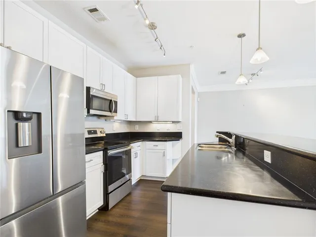 a kitchen with kitchen island a counter space a sink a stove and refrigerator