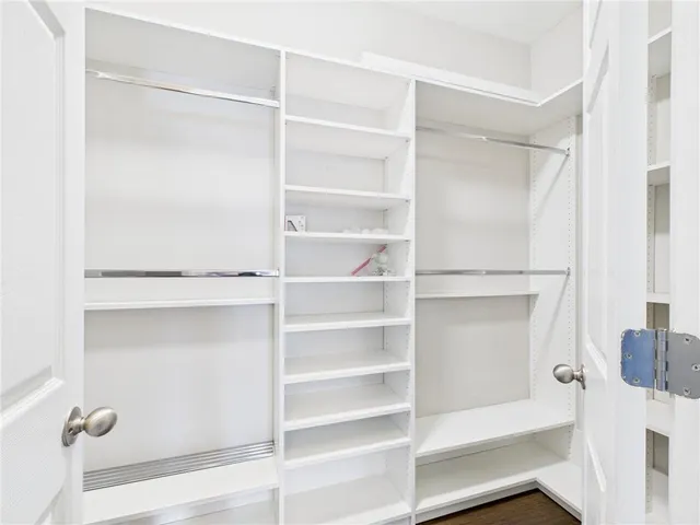 a view of walk in closet with empty racks