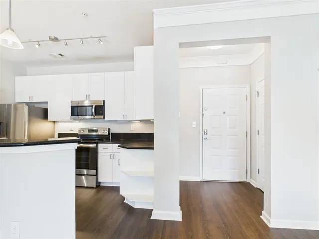 a kitchen with stainless steel appliances a stove top oven a sink a counter top space and cabinets