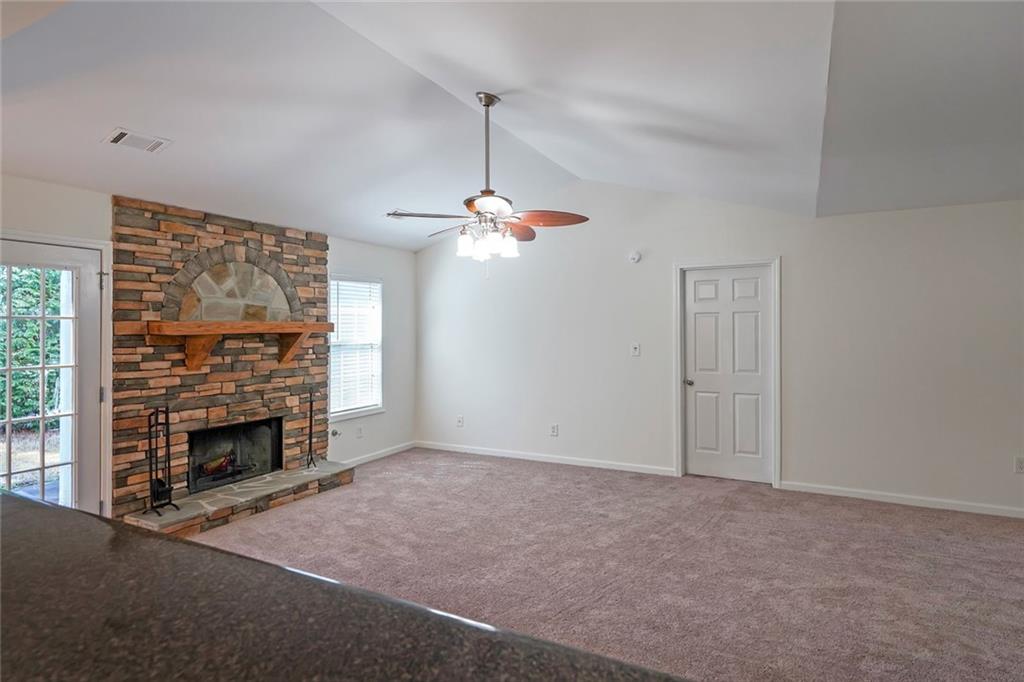 211 West Bridge Drive Dallas, GA 30157 - Photo 11 of 26 a view of a livingroom with a fireplace a ceiling fan and windows