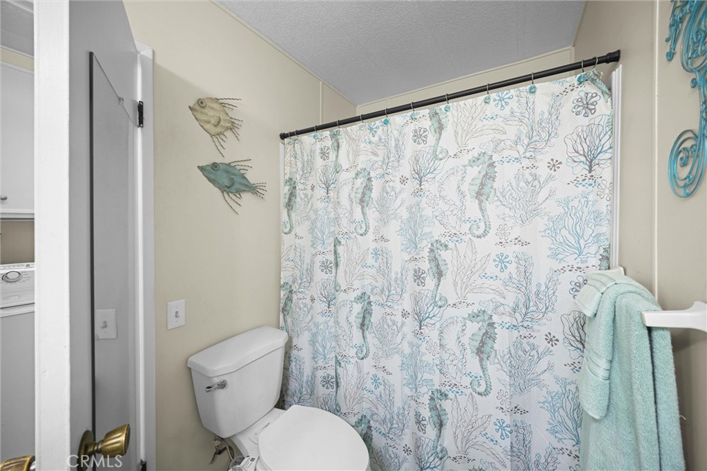 9800 Base Line Road, Unit 71 Rancho Cucamonga, CA 91701 - Photo 15 of 42 a white toilet sitting next to a shower curtain
