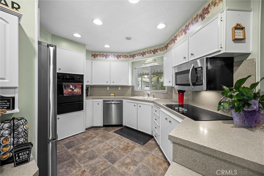 9800 Base Line Road, Unit 71 Rancho Cucamonga, CA 91701 - Photo 17 of 42 a kitchen with granite countertop a sink stainless steel appliances and white cabinets