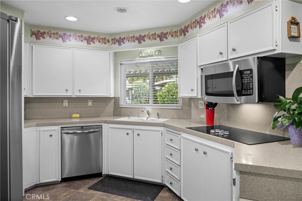 9800 Base Line Road, Unit 71 Rancho Cucamonga, CA 91701 - Photo 18 of 42 a kitchen with granite countertop a sink stainless steel appliances and white cabinets