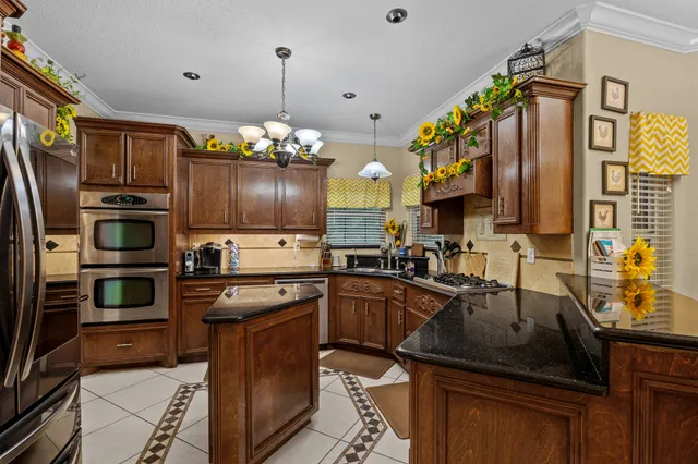 a kitchen with granite countertop a sink cabinets and stainless steel appliances