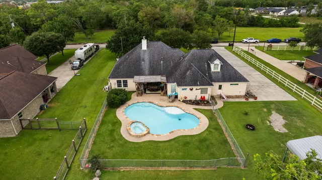 an aerial view of a house with swimming pool and outdoor seating
