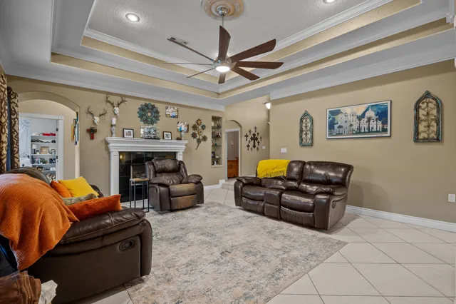 a living room with furniture a flat screen tv and a wall painting