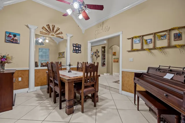 a view of a dining room with furniture and a chandelier fan