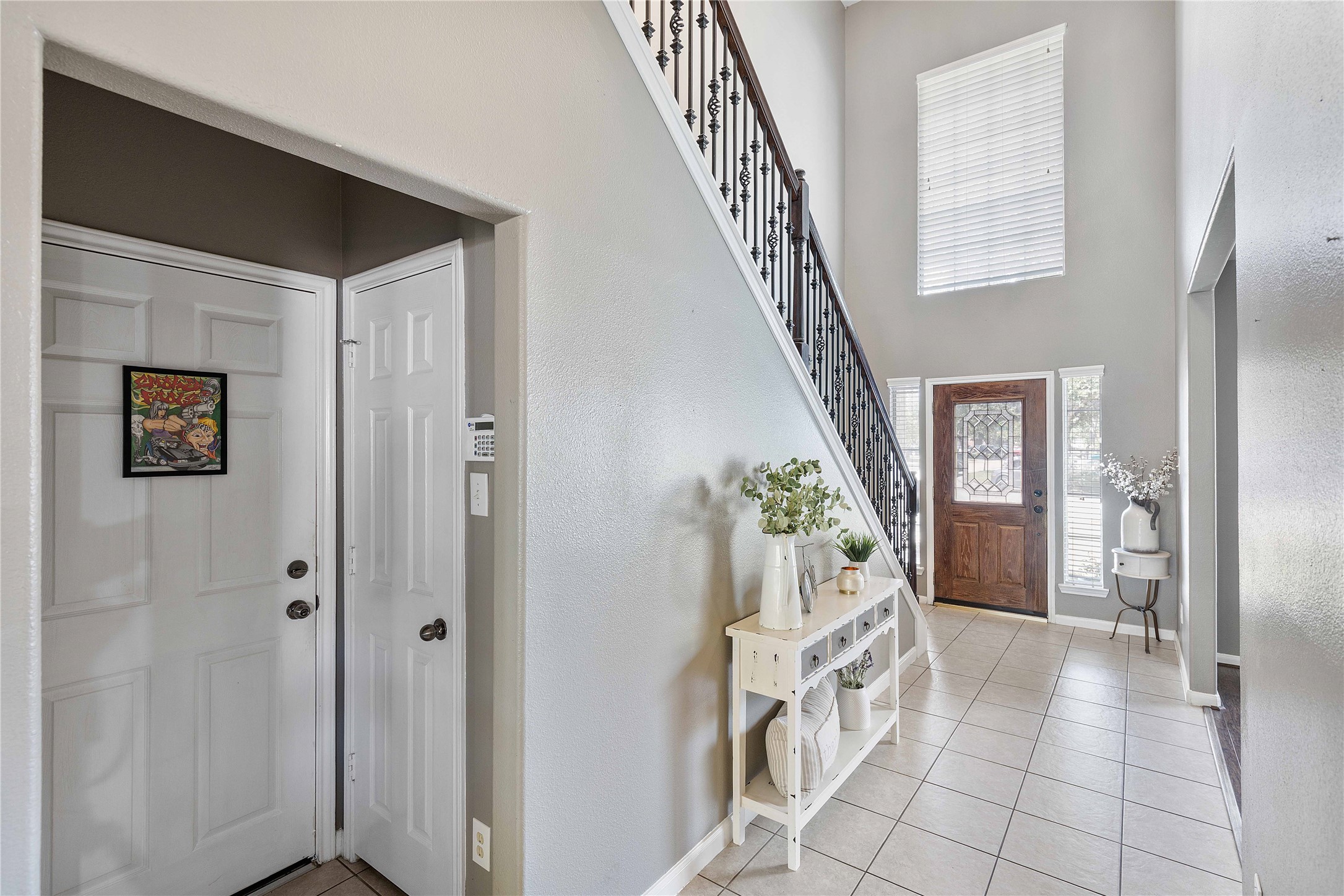24506 Fort Path Drive Spring, TX 77373 - Photo 4 of 46 Inviting entryway with a high ceiling and abundant natural light, featuring elegant tile flooring and a decorative staircase leading to the upper level.