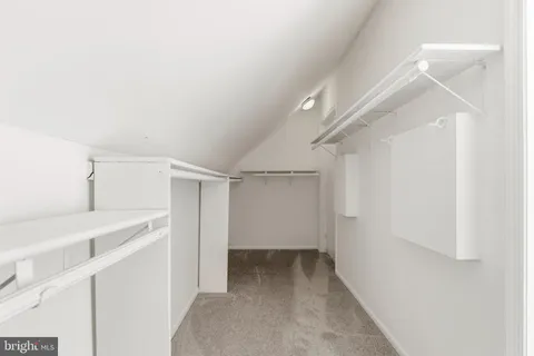 a view of walk in closet with empty racks
