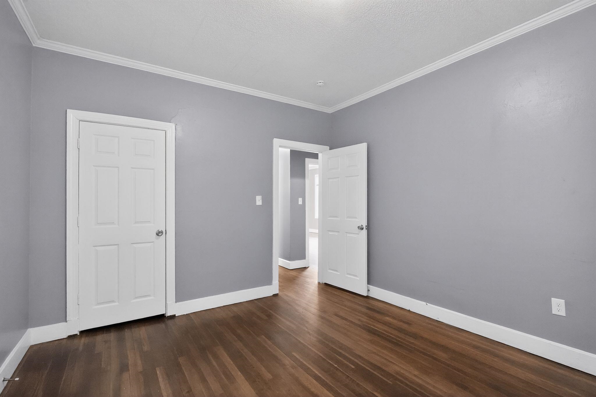 4199 Auburn Road Memphis, TN 38116 - Photo 22 of 32 Room featuring wood-finish flooring, light gray walls, white baseboards, and white crown molding