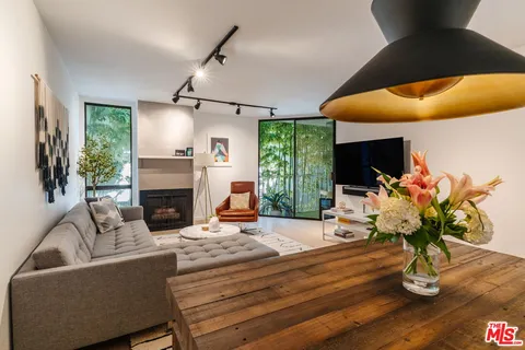 a living room with furniture fireplace and potted plants