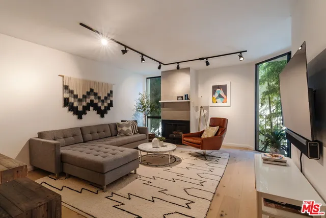 a living room with furniture a fireplace and a flat screen tv