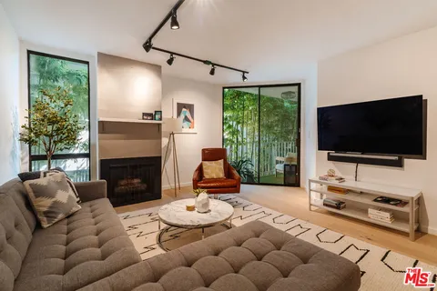 a living room with furniture a flat screen tv and a large window