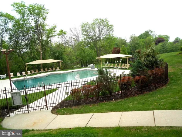 a view of backyard with swimming pool and seating