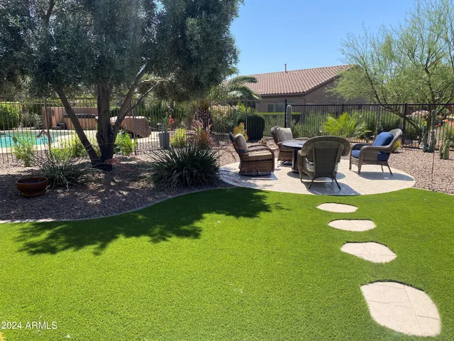 a view of a backyard with table and chairs under an umbrella