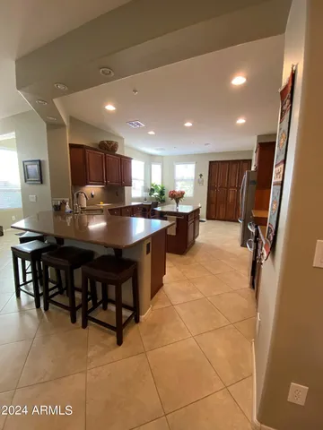 a kitchen with stainless steel appliances granite countertop a sink counter and chairs