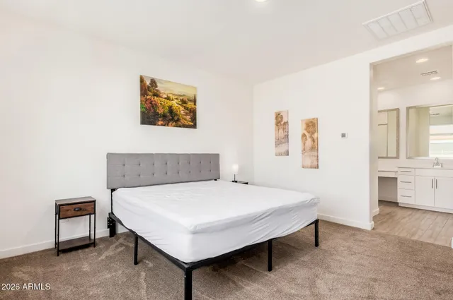 a bedroom with a bed a table and painting