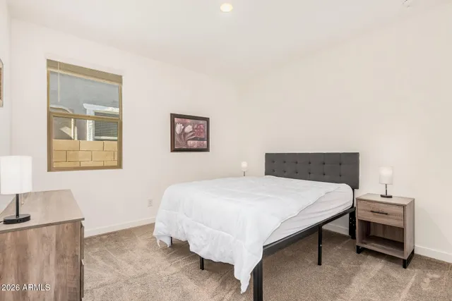 a bedroom with a bed and a lamp on table