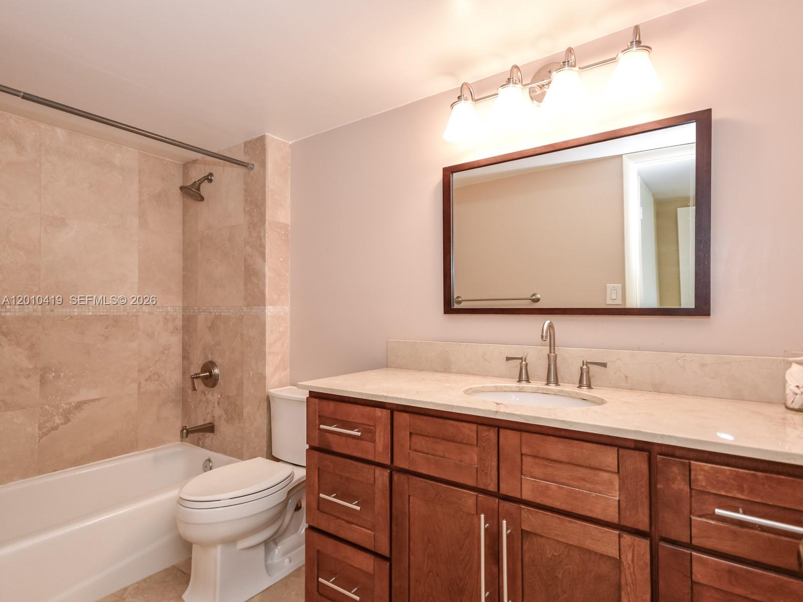 780 Northeast 69th Street, Unit 1908 Miami, FL 33138 - Photo 10 of 18 a bathroom with a double vanity sink toilet mirror and bathtub