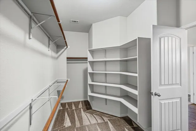 a view of walk in closet with empty racks