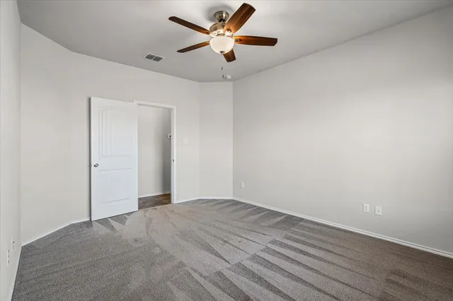 a view of a big room with wooden floor and a ceiling fan