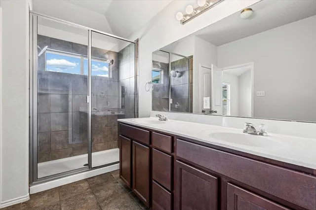 a bathroom with a shower sink and mirror