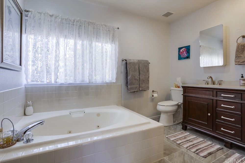 2725 Alta Vista Drive Fallbrook, CA 92028 - Photo 29 of 50 a bath room with a toilet a sink and a bath tub