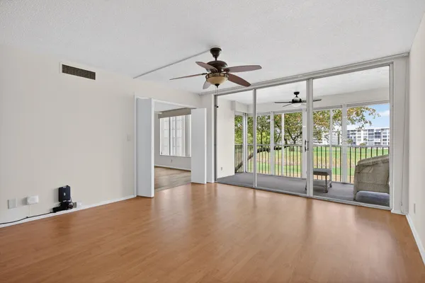 a view of a livingroom with wooden floor and a ceiling fan
