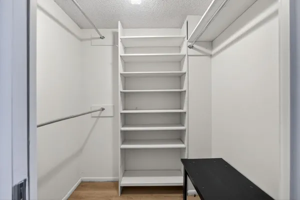 a view of walk in closet with empty racks