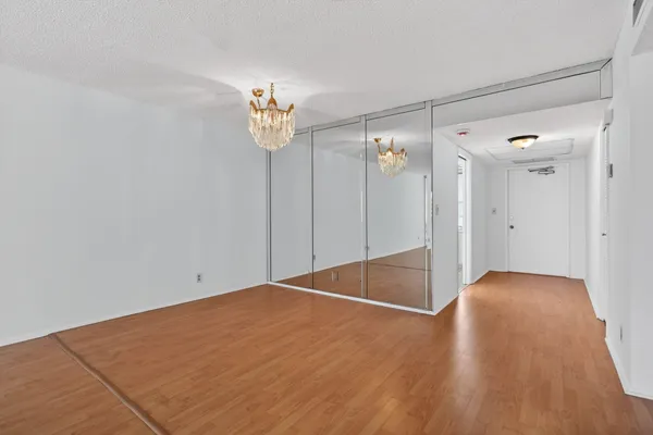 a view of empty room with wooden floor and ceiling fan