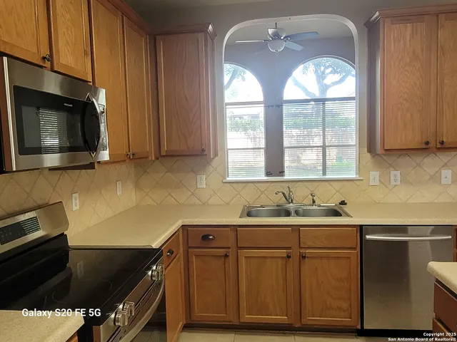 a kitchen with stainless steel appliances wooden cabinets and a sink