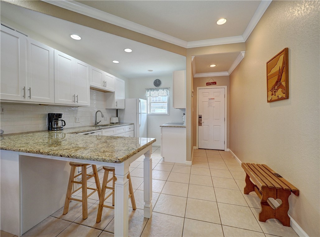 700 Island Retreat Road, Unit 37 Port Aransas, TX 78373 - Photo 12 of 34 a kitchen with stainless steel appliances granite countertop a sink and cabinets