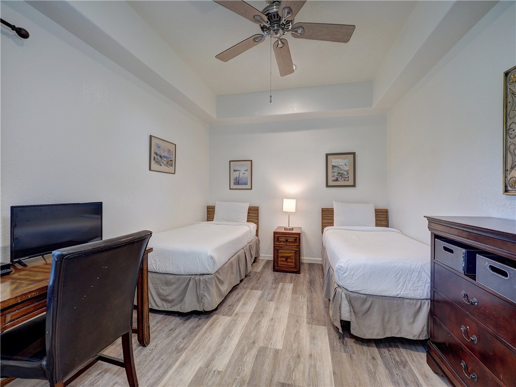700 Island Retreat Road, Unit 37 Port Aransas, TX 78373 - Photo 19 of 34 a bedroom with a bed and a chandelier