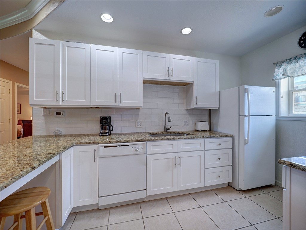 700 Island Retreat Road, Unit 37 Port Aransas, TX 78373 - Photo 7 of 34 a kitchen with white cabinets sink and white appliances