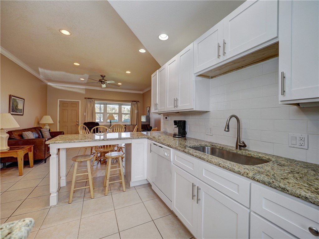 700 Island Retreat Road, Unit 37 Port Aransas, TX 78373 - Photo 8 of 34 a kitchen with cabinets and chairs