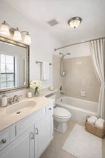 a bathroom with a double vanity sink toilet mirror and bathtub
