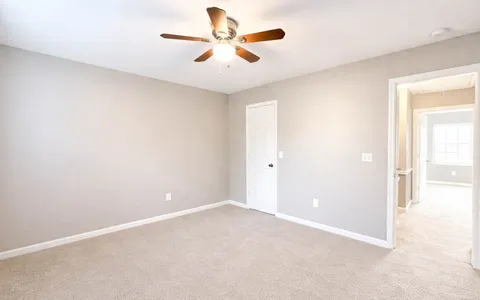 an empty room with chandelier fan