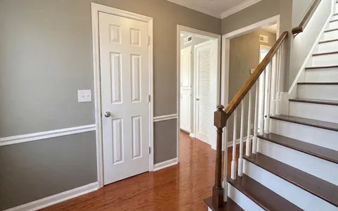 an entryway with wooden floor and stairs